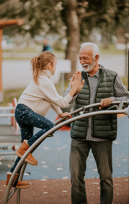 grandfather spending time with his granddaughter at the playground secure future
